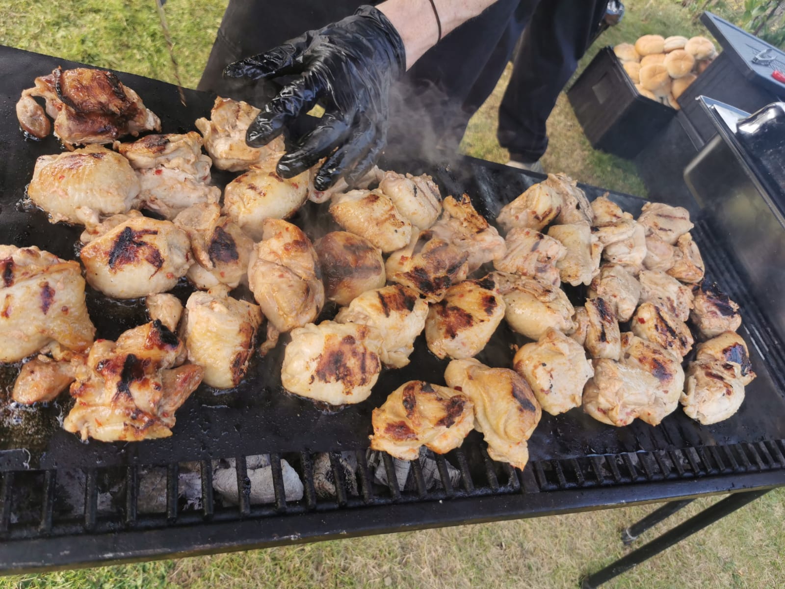 Wedding BBQ catering Essex guests enjoying freshly grilled chicken prepared outdoors 